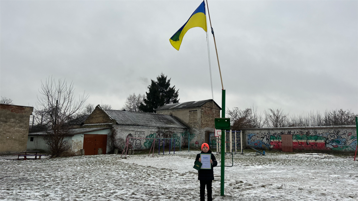 Влад біля свого прапора у дворі.