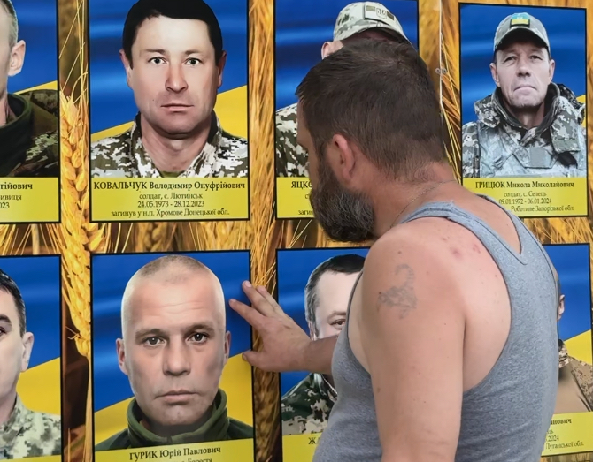 Денис «Борода» біля портрету загиблого побратима.