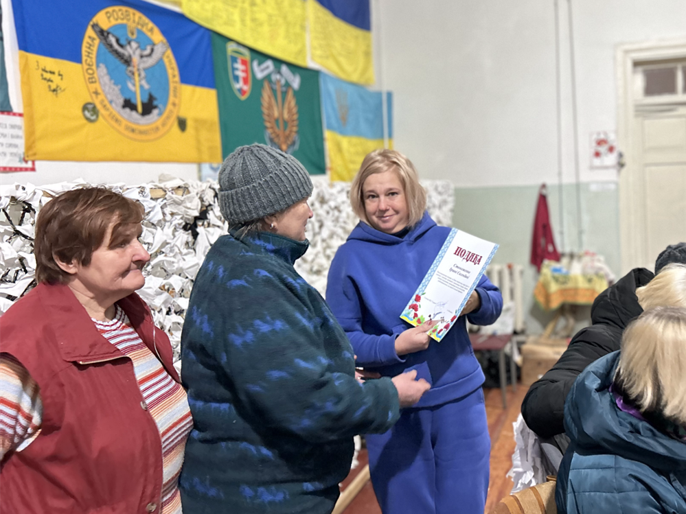 Ірина Стоноженко отримує подяку від волонтерського центру.