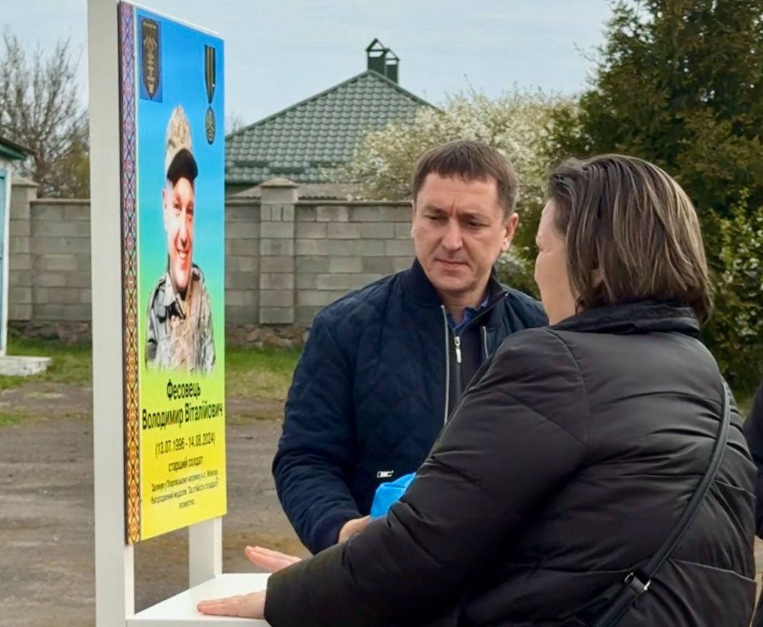 Мама воїна Валентина Фесовець і Сарненський міський голова Руслан Серпенінов відкривають меморіальну дошку.