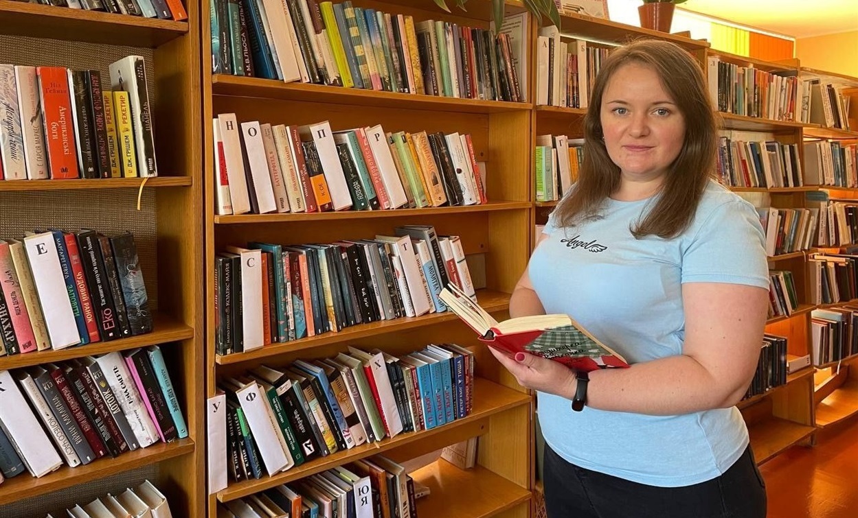 Наталія Фролова в пошуках чергової книги на полицях бібліотеки.