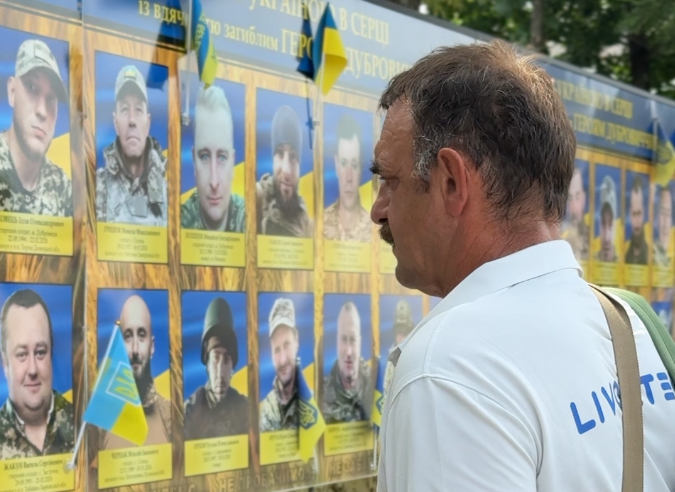 Володимир Кузьмич біля портретів загиблих захисників.