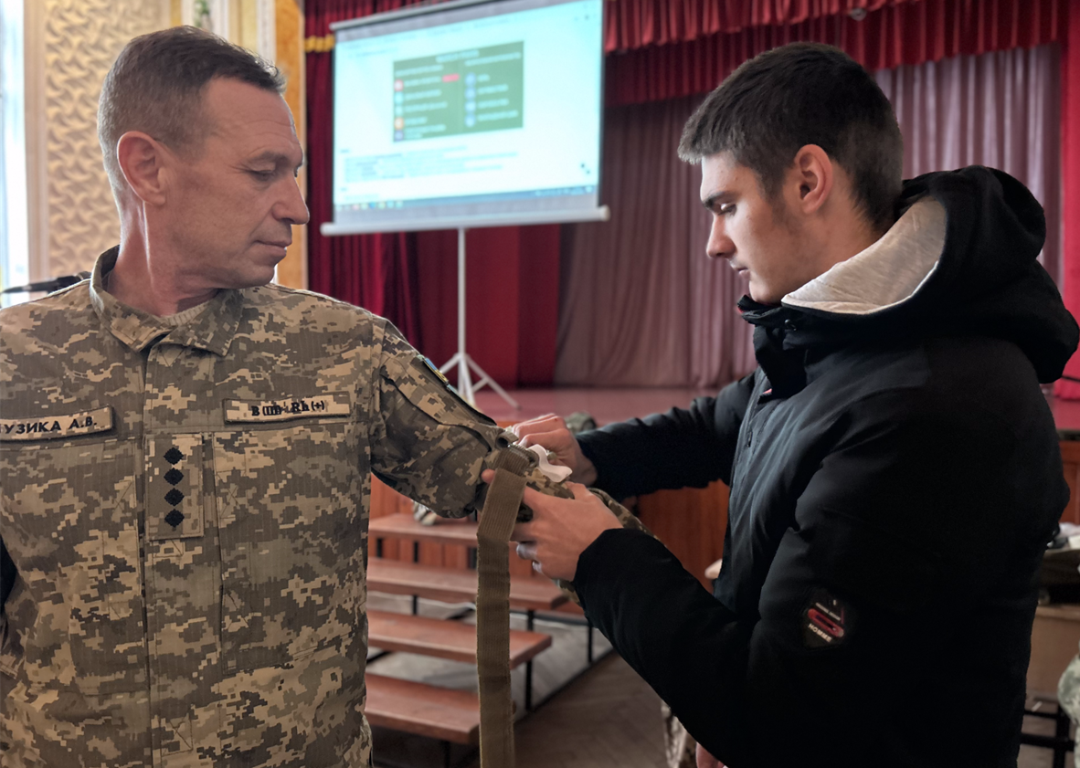 Віктор накладає тренувальний турнікет викладачу Андрію Музиці.